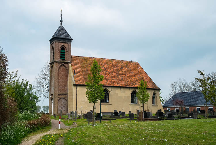 Het kerkje van Dorkwerd staat fraai bovenop de wierde met ernaast het kerkhof.