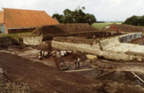 Op de achtergrond zien we de schuur van de boerderij nr. 162.
Op de voorgrond is men bezig om een deel van de wierde af te graven.
In het midden is een deel van het hunebed zichtbaar. Foto circa 1983. Bron: eigen verzameling.