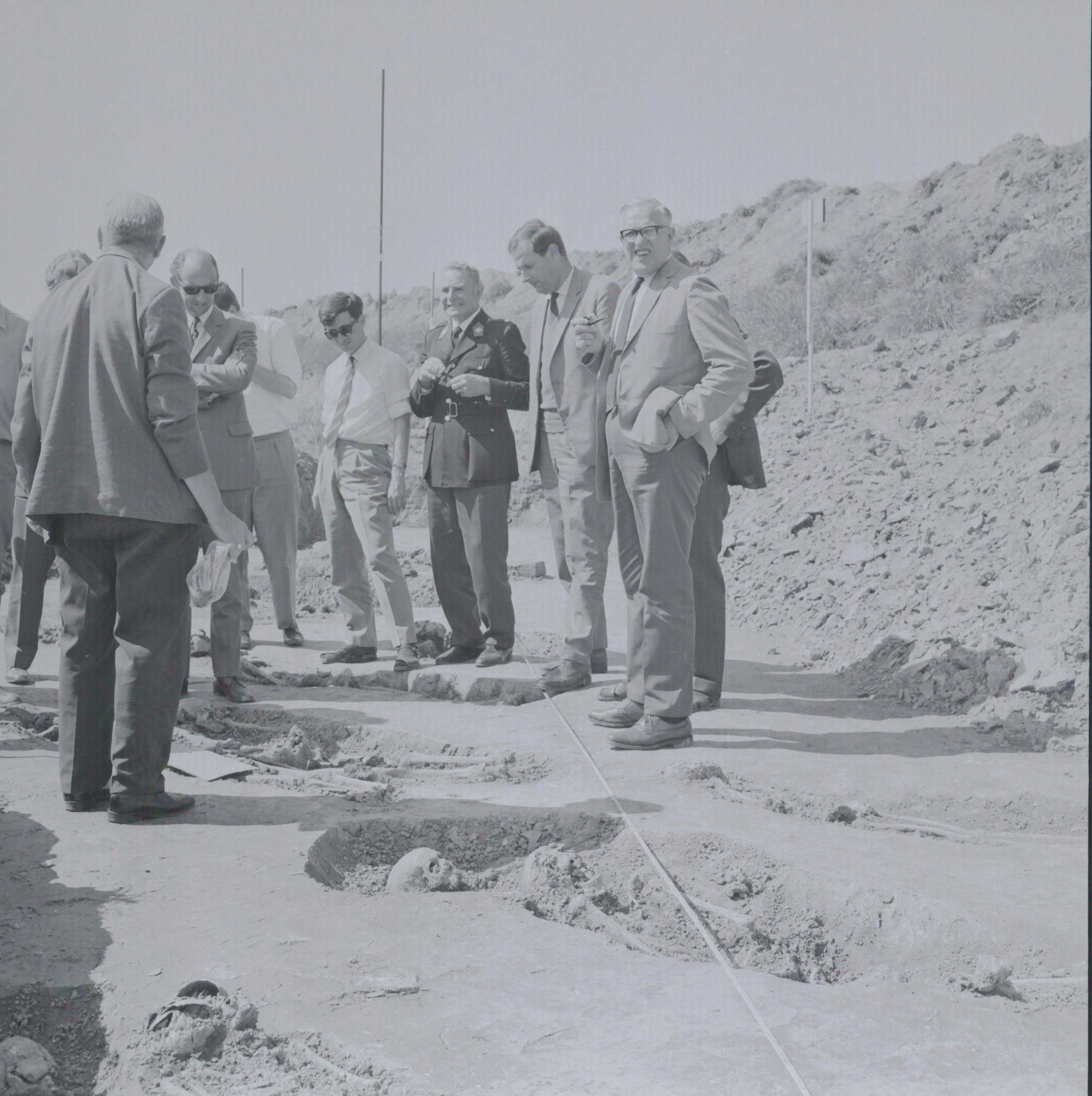 Bij het onderzoek in 1969 voert de B.A.I. de werkzaamheden uit. Slechts één graf is omsloten dor een bakstenen muurtje. De Rijkspolitie volgt het een en ander. Foto: 1969, van een negatief, RHC GA, Groninger Archieven, Beeldbank Groningen.
