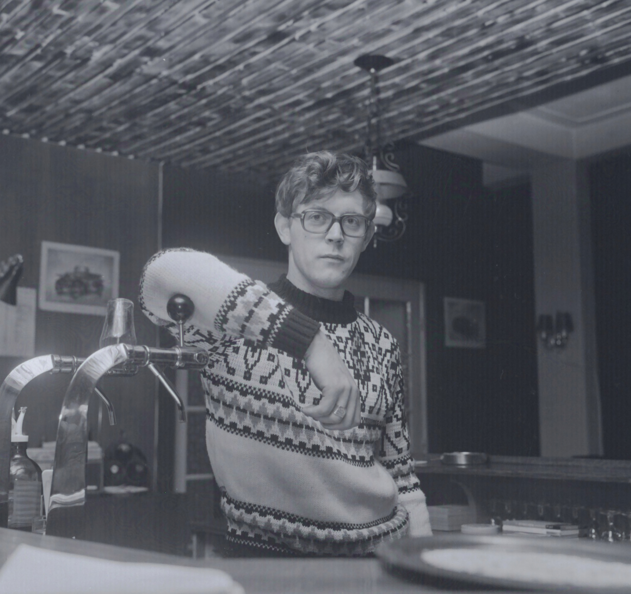 Caféhouder Jacob de Groot te Woldendorp poseert achter de tap. Foto van een negatief. Vervaardiger: Persbureau D. van der Veen, circa 1972. Bron: RHC GA, Groninger Archieven.
