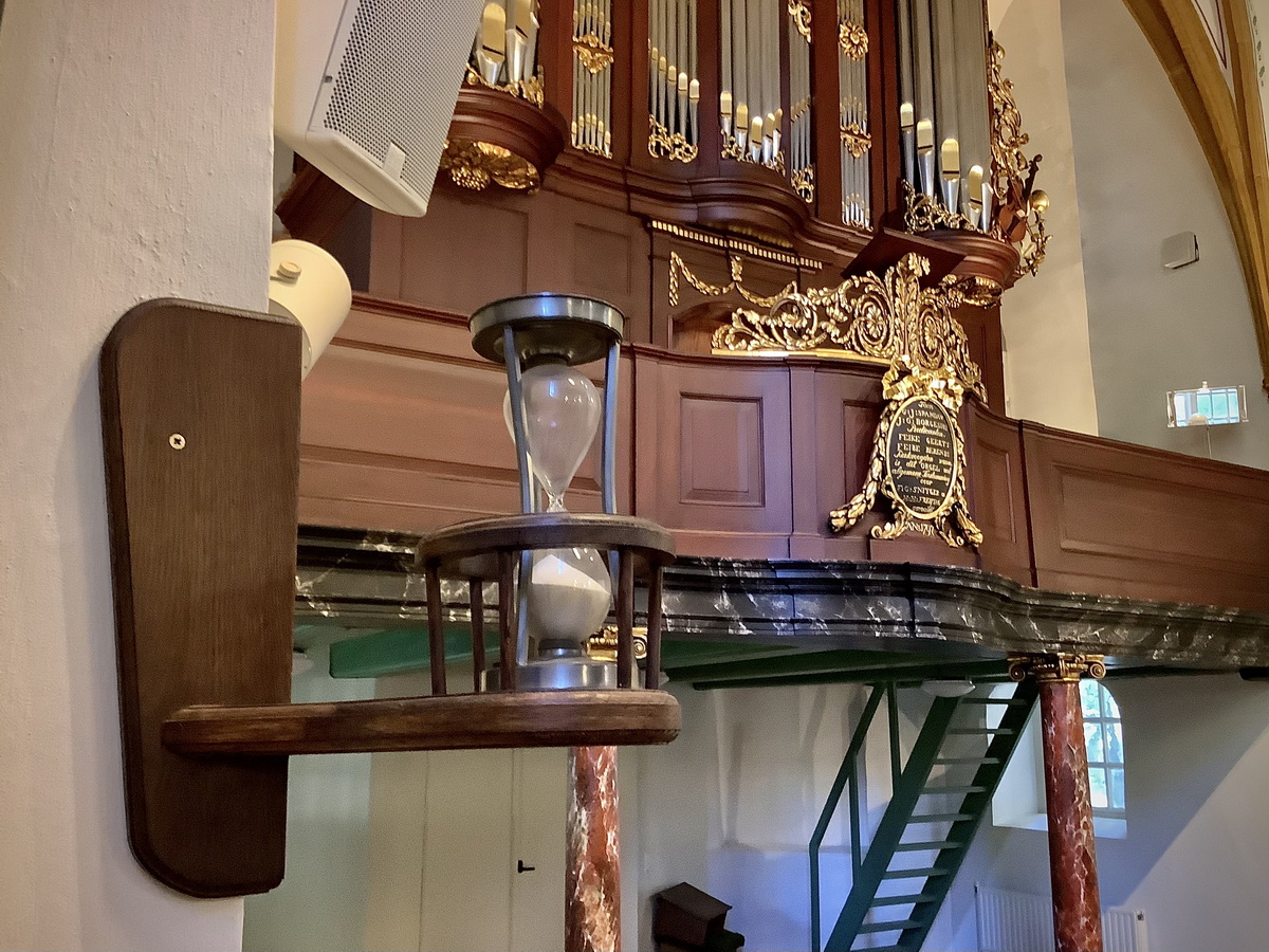 Links van het orgel staat een merkwaardige zandloper. Foto: ©Jur Kuipers.