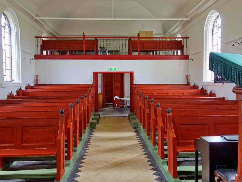 Zicht op de balustrade. Er is geen orgel aanwezig. Interieur van de kerk ná de restauratie van 2010.