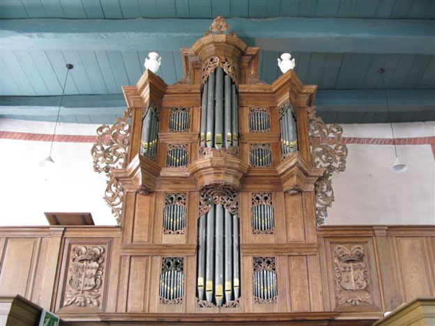 fig. 7. Orgel in de kerk van Eenum in 1704 door Arp Schnitger gebouwd. Op de borstwering de wapens Alberda-Jarges en Horenken- Van Isselmuden. 