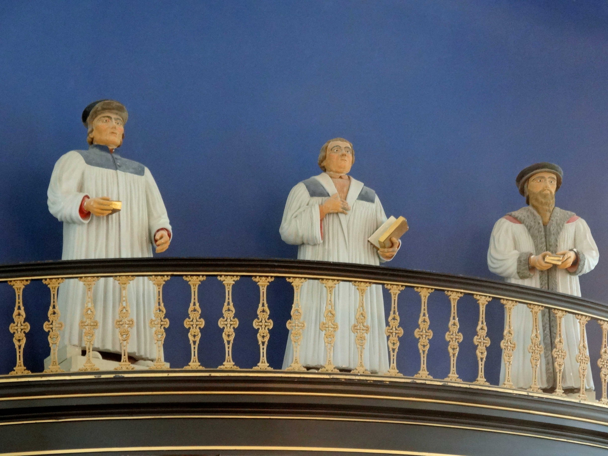 Foto boven: Heel bijzonder en buitengewoon voor een protestantse kerk is de aanwezigheid van een drietal beelden van gips. Het zijn de beelden van de kerkhervormers Calvijn, Zwingli en Luther. Ze zijn in 1869 in de kerk geplaatst.