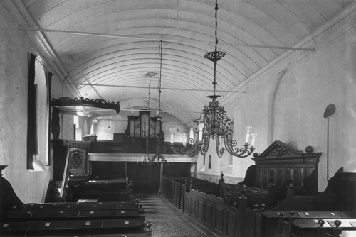 Foto onder: Het kerkinterieur vóór de verbouwing (1941) met de preekstoel, herenbank, galerij met Martin Vermeulen-orgel en kerkbanken Daarna is er van het oorspronkelijke interieur weinig meer over.