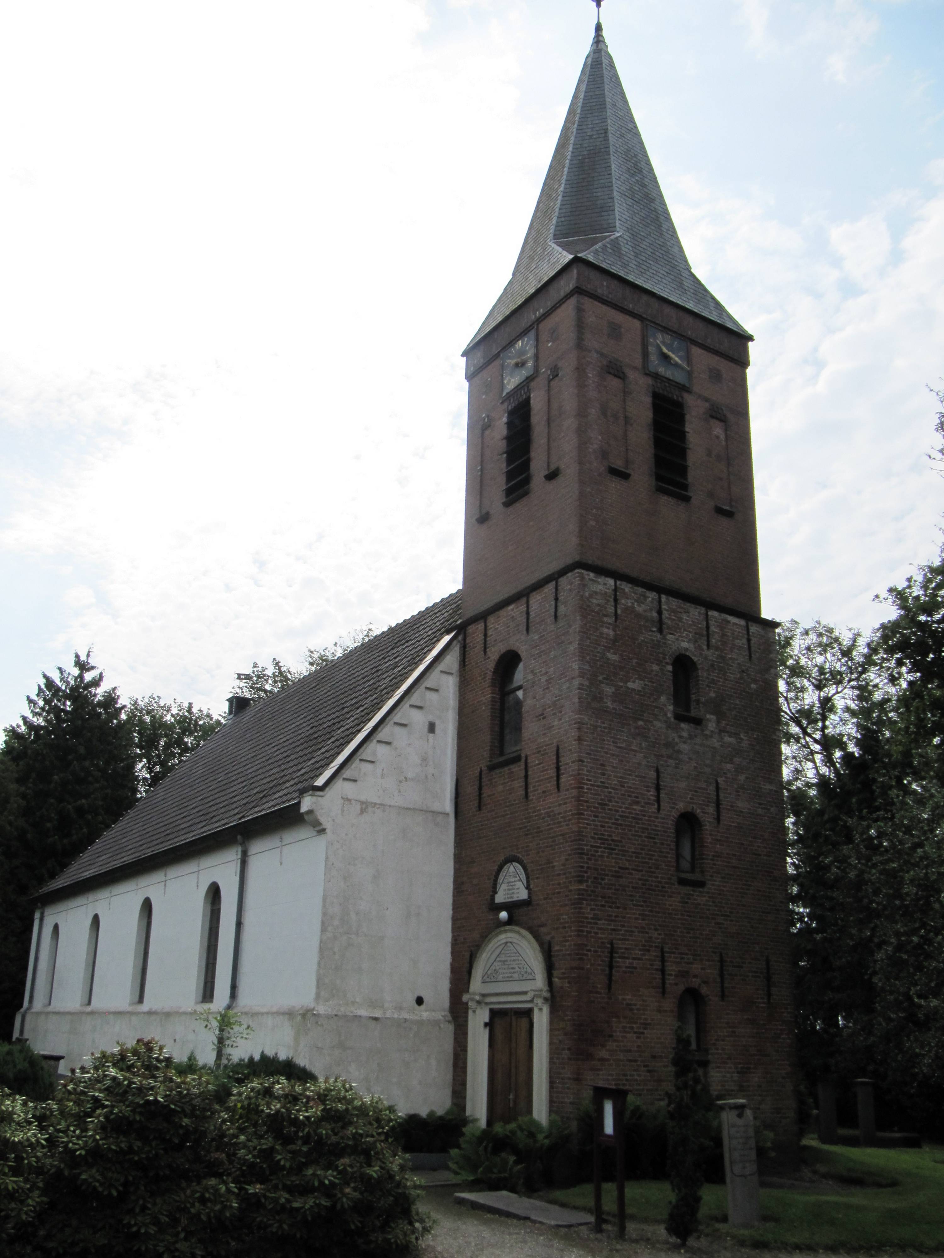 Het kerkgebouw met toren en ingang.