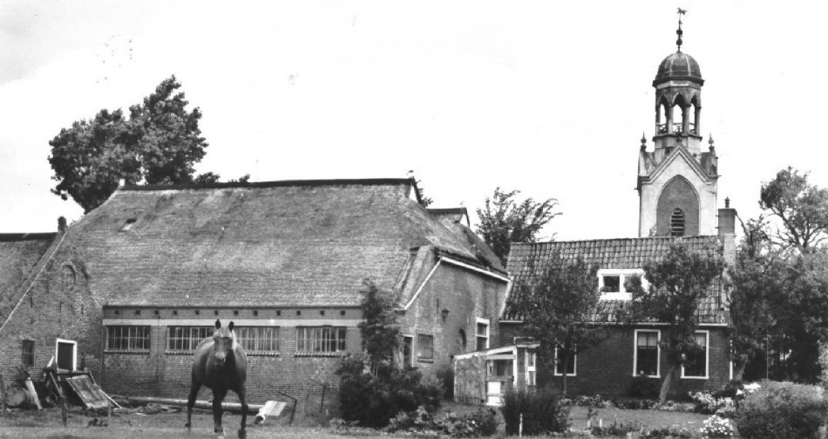 Een foto van de naast het kerkhof gelegen boerderij en daarachter de toren. Bron: ZoAstWas.nl, website Historische Vereniging gemeente Bedum.
