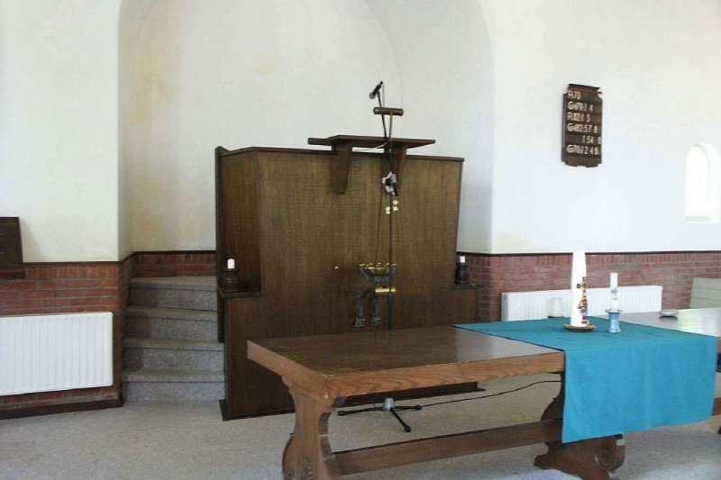 Interieur van de voormalige Gereformeerde kerk met kansel een Avondmaalstafel 