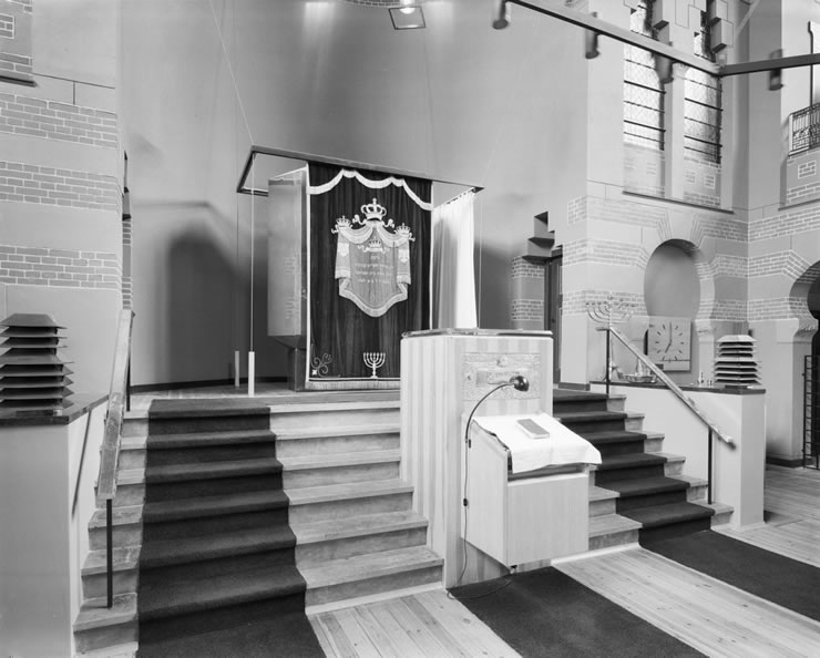 Interieur van de synagoge te Groningen met Heilige Arke, lessenaar en negenarmige kandelaar.