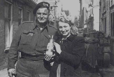 Een Groningse vrouw met haar Canadese bevrijder en een fles Bols. Bron: Bevrijdingskinderen