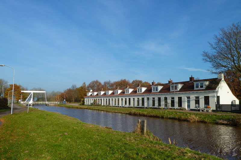 De Tienborg met op de achtergrond de klapbrug over de Scharmer Ae. De witte huisjes in Woudbloem zijn een beschermd dorpsgezicht van de gemeente Slochteren. De huisjes worden aardbevingsbestendig gemaakt.