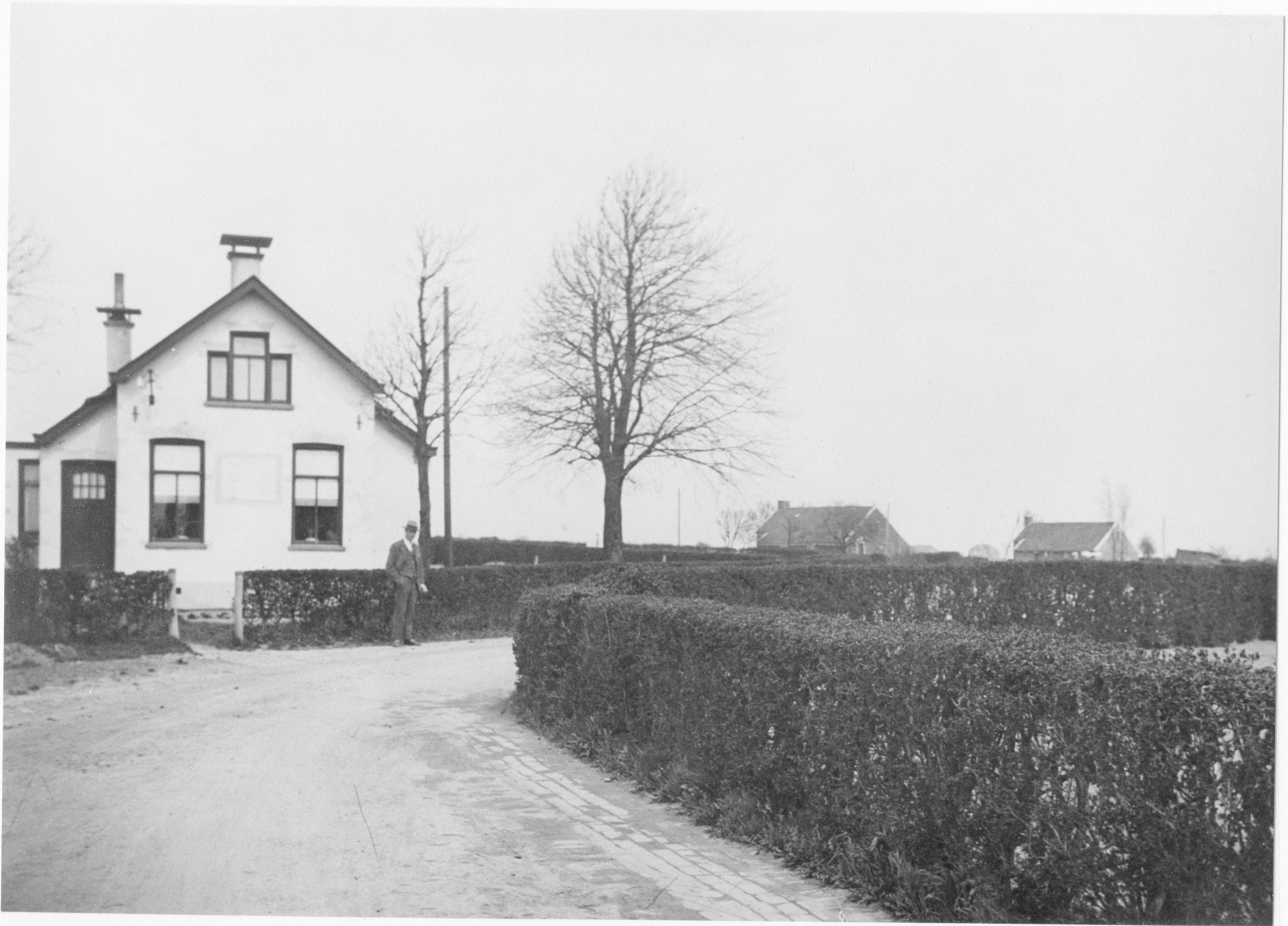 Arbeidershuizen aan de Polderweg in de Oostwolderpolder gezien vanaf Oostwold, vóór de bestrating van de weg. Gedateerd: 1928. Bron: Beeldbank Groninger Archieven.